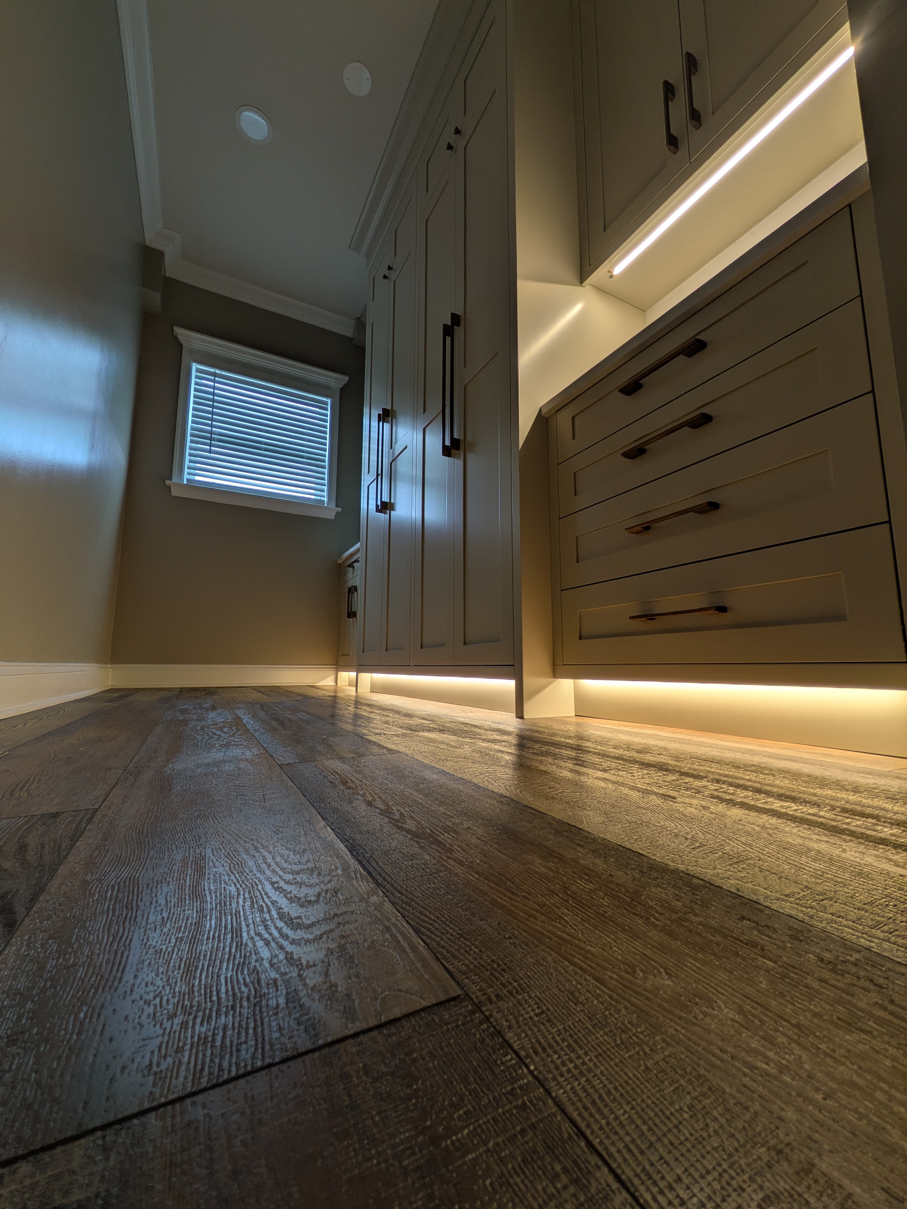Custom mudroom cabinetry with integrated toe kick lighting